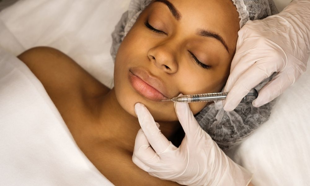 African american female receiving dermal fillers at a dermatology office