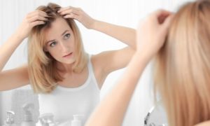 caucasian female examining thinning hair